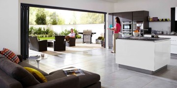 Bi-fold doors are used as part of a kitchen extension by creating a large open space with the garden