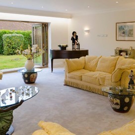 A large lounge with fully open bifold doors looking into the garden
