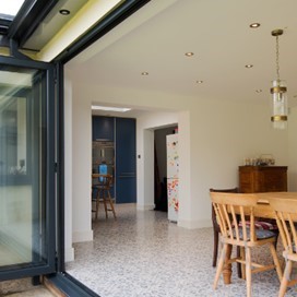 Origin bifold doors fully open looking into the kitchen and dining area