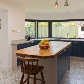 A zoomed out view of the bifold doors and bay window from inside the kitchen area