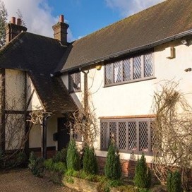 Side view of old cottage house with bush running below the window