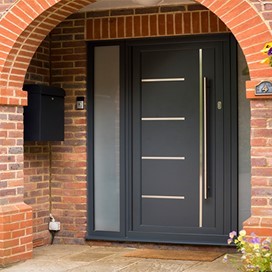View of a black Origin Front door underneath a curved porch