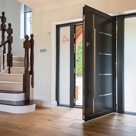 An open black bifold door from the inside of a home 