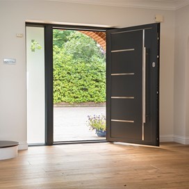 Inside of a modern home with an open Origin front door leading onto the front