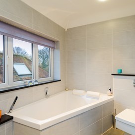 An internal view of a closed bathroom windows and blind