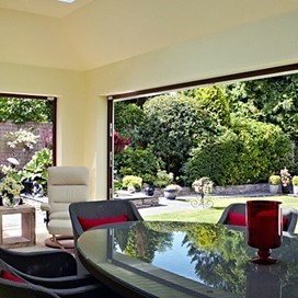 Large open doors from an extension out to the garden in the Sun