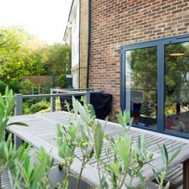 An external view from an upper story decking area through large glass doors