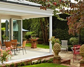 Shot of outside a house on a white patio with chairs and table