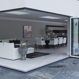 Looking into a bright and modern dining area through open corner doors