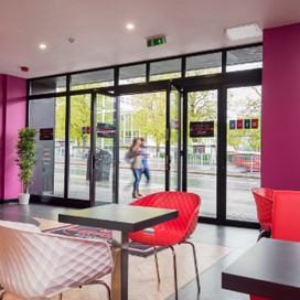 An interior shot showing the counter and some tables of Sundaes Gelato ice cream parlour with Origin doors opening out onto the street