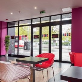 An interior shot showing the counter and some tables of Sundaes Gelato ice cream parlour looking out onto the street