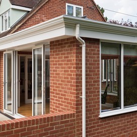 Corner of house with a white pipe down the building