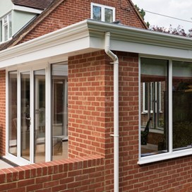 Corner of house with a white pipe down the building