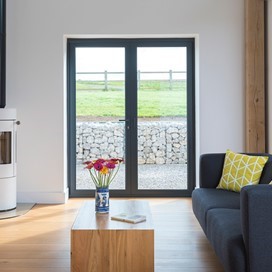 Living room looking through bifold doors with flowers on the middle of the table