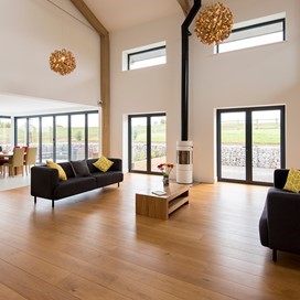 Large living room shot with table and red flowers in the middle of the room