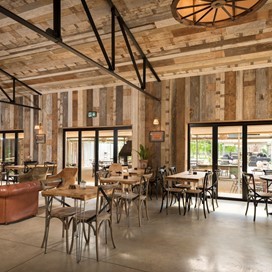 Dining hall looking out onto a farm through bifold doors