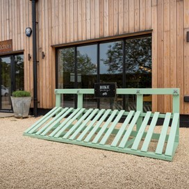 Outside of a farm shop showing a blue bicycle rack