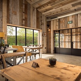 Dining hall looking out onto a farm through bifold doors