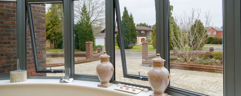 A close up of partially opened bay windows looking out onto the forecourt
