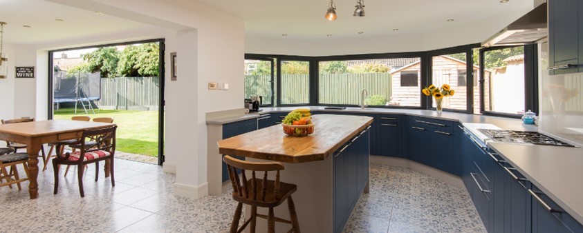 A zoomed out view of the bifold doors and bay window from inside the kitchen area