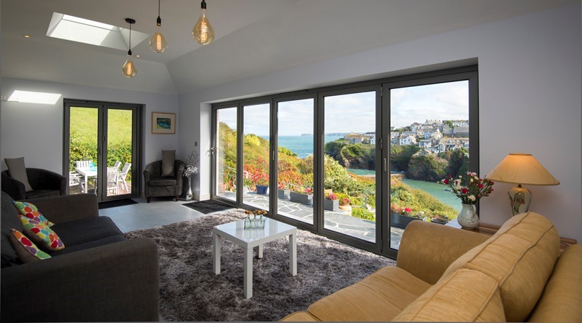 Dining room view looking through bifold doors onto a large garden