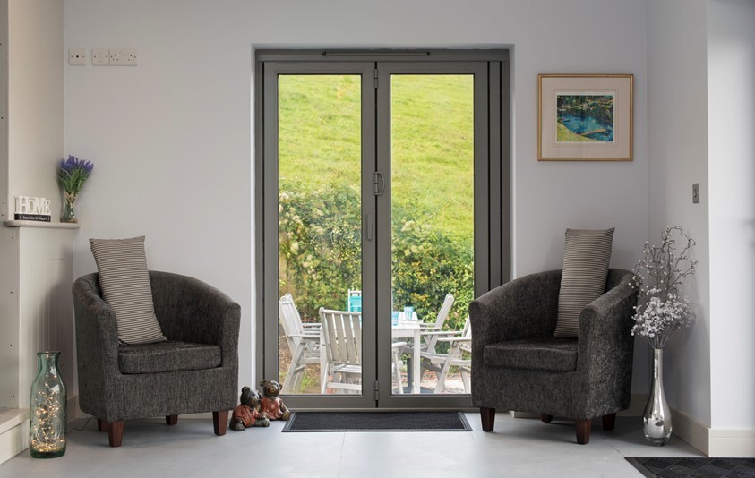 Inside of a home looking through a origin french door looking into a garden