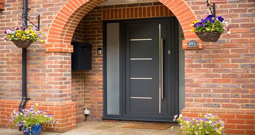 View of a black Origin Front door underneath a curved porch