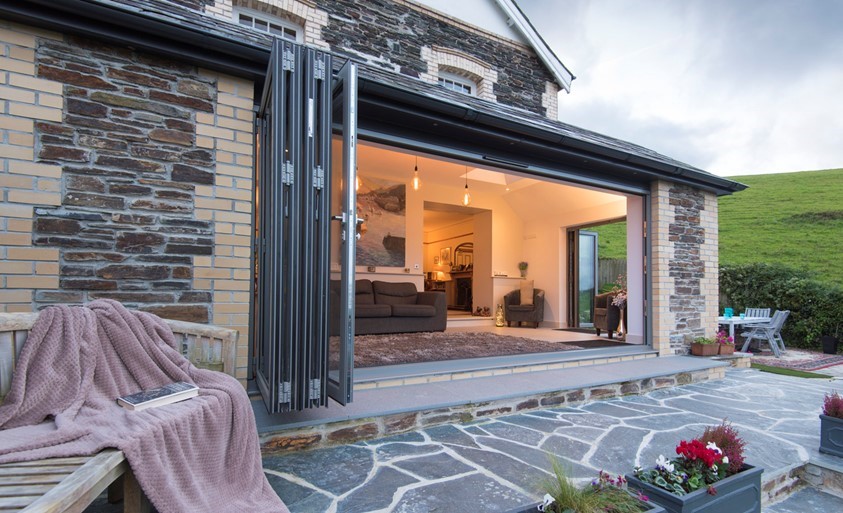 Origin bifold doors open leading into a modern and well lit dining room