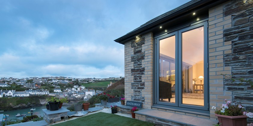 Outside view of a home fitted with bifold doors looking over a night time landscape