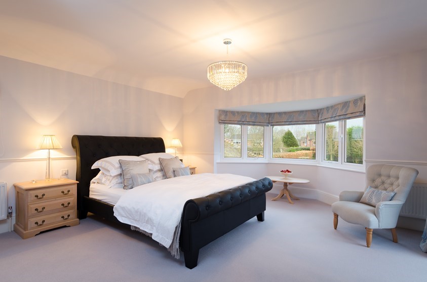An internal shot of a bedroom with a bay window