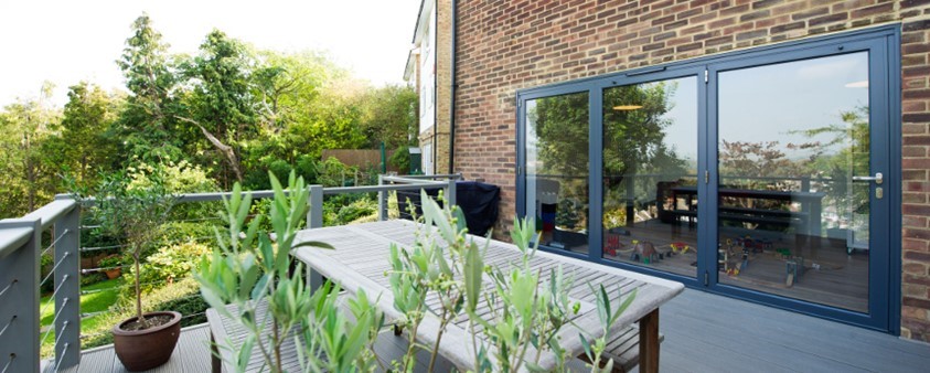 An external view from an upper story decking area through large glass doors