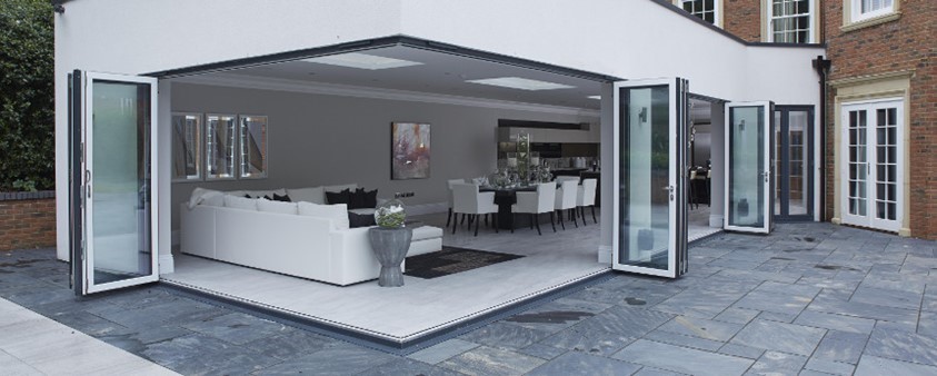 Looking into a bright and modern dining area through open corner doors