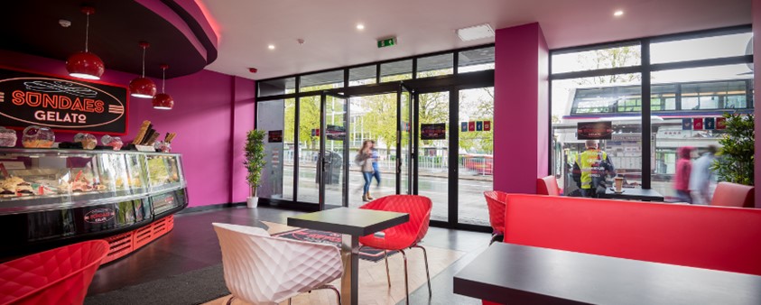 An interior shot showing the counter and some tables of Sundaes Gelato ice cream parlour with Origin doors opening out onto the street