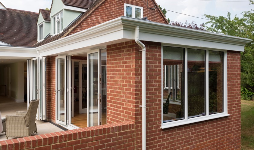Corner of house with a white pipe down the building