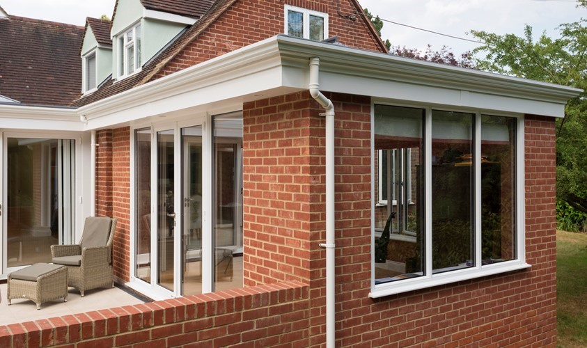 Corner of house with a white pipe down the building