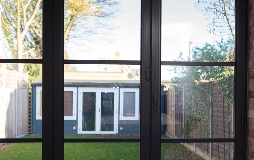 Closed bifold doors looking through to a back building