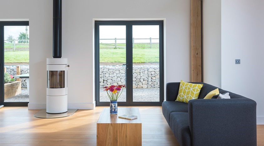 Living room looking through bifold doors with flowers on the middle of the table 