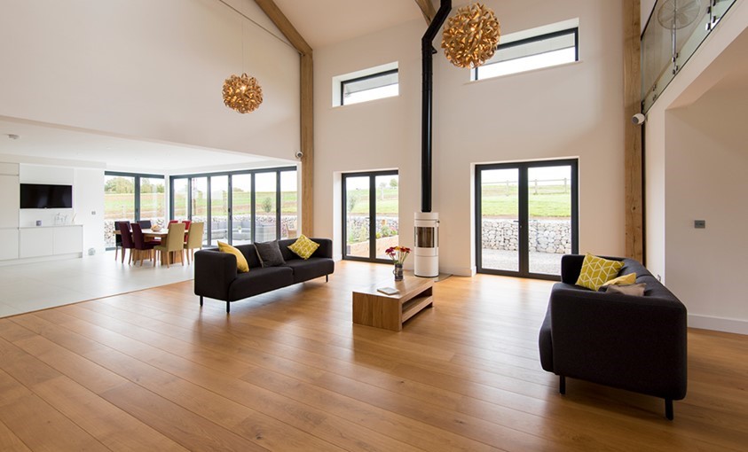 Large living room shot with table and red flowers in the middle of the room