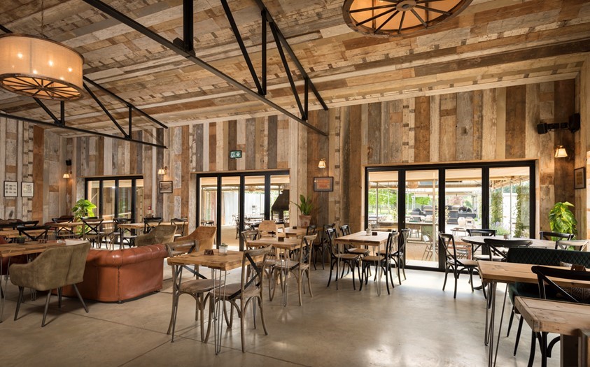 Dining hall looking out onto a farm through bifold doors