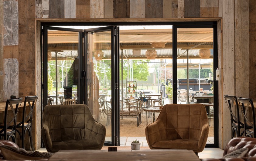 Open bifold doors leading out into the garden and outdoor section of the cafe