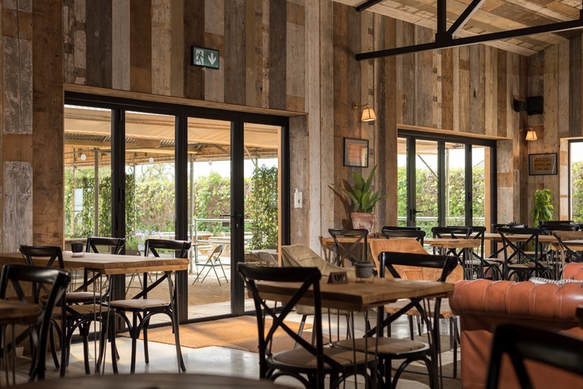 Dining hall looking out onto a farm through bifold doors