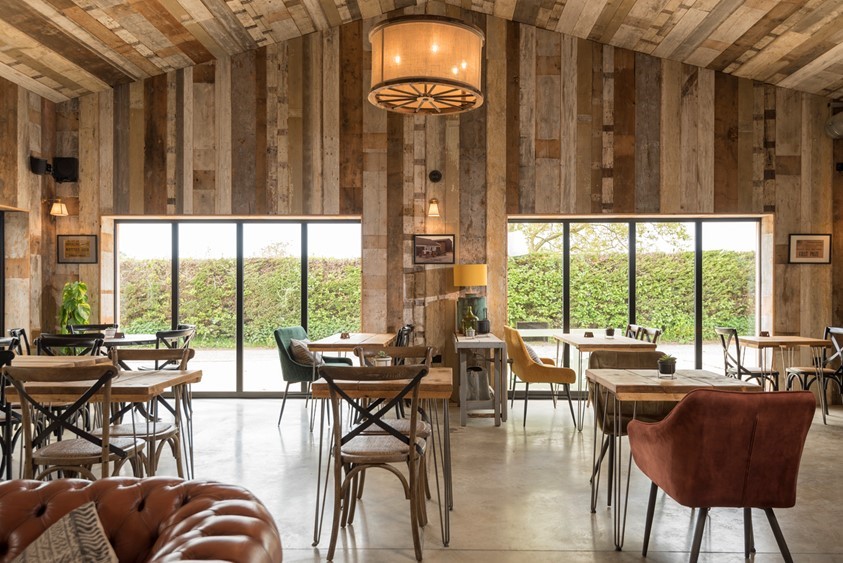 Dining hall looking out onto a farm through bifold doors