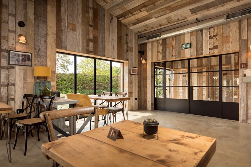 Dining hall looking out onto a farm through bifold doors