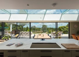 A dreamy kitchen area surrounded with walls of slim sightlines and glass views hosted by Origin’s Artisan Slider & Picture Windows